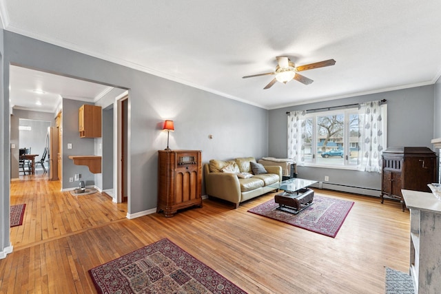 living room featuring hardwood / wood-style flooring, a baseboard heating unit, a ceiling fan, baseboards, and ornamental molding