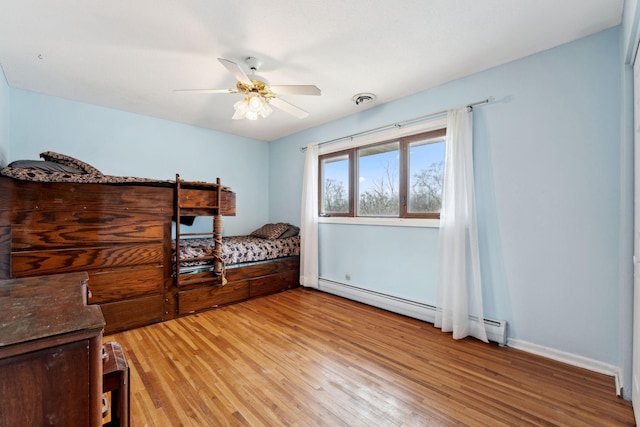 bedroom with visible vents, baseboards, a ceiling fan, a baseboard radiator, and light wood-type flooring