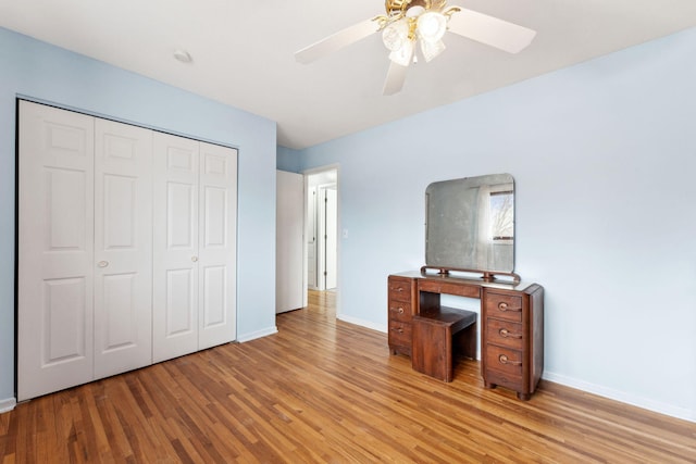 unfurnished office featuring light wood-type flooring, ceiling fan, and baseboards