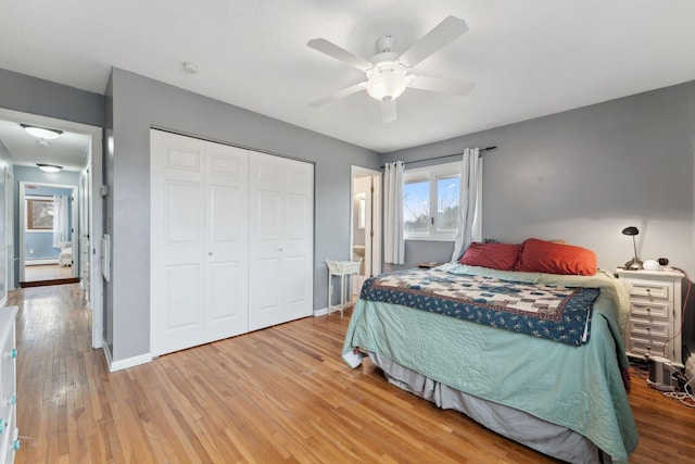 bedroom featuring ceiling fan, a closet, baseboards, and hardwood / wood-style floors