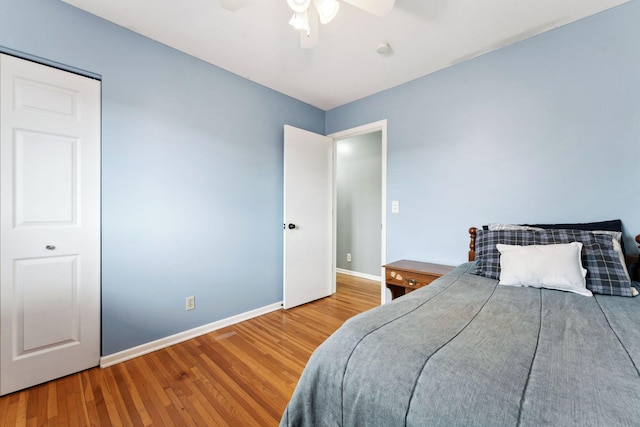 bedroom with ceiling fan, baseboards, and wood finished floors