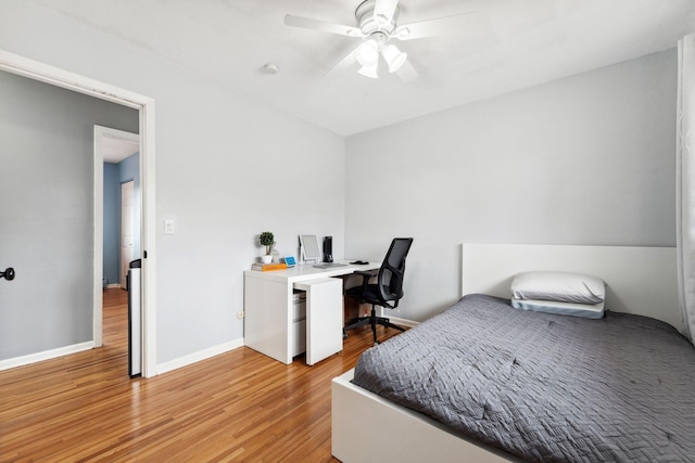 bedroom featuring ceiling fan, light wood finished floors, and baseboards