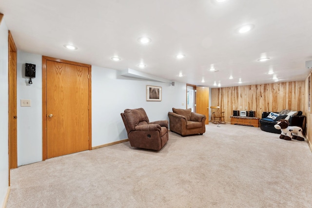 carpeted living area featuring recessed lighting and wood walls