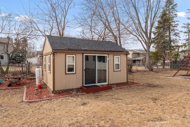 view of outdoor structure featuring a fenced backyard and an outbuilding