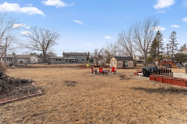 view of yard featuring a residential view, an outdoor structure, and fence