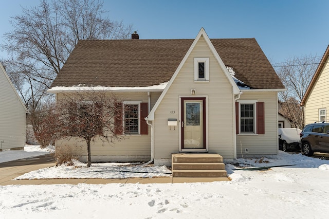 view of front of property with roof with shingles and a chimney