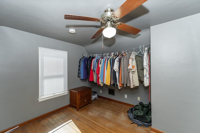 walk in closet featuring lofted ceiling, visible vents, and wood finished floors