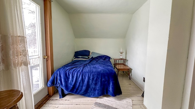 bedroom featuring wood finished floors and vaulted ceiling