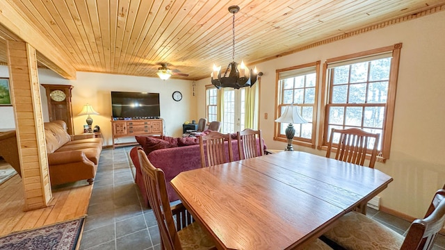 dining room with dark tile patterned floors, a notable chandelier, and wooden ceiling