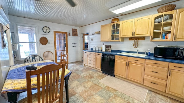 kitchen with dark countertops, light brown cabinets, stone finish floor, black appliances, and a sink