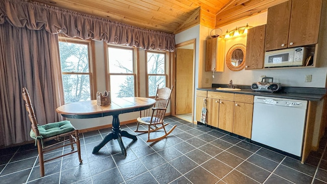 kitchen with white appliances, a sink, vaulted ceiling, dark countertops, and wooden ceiling