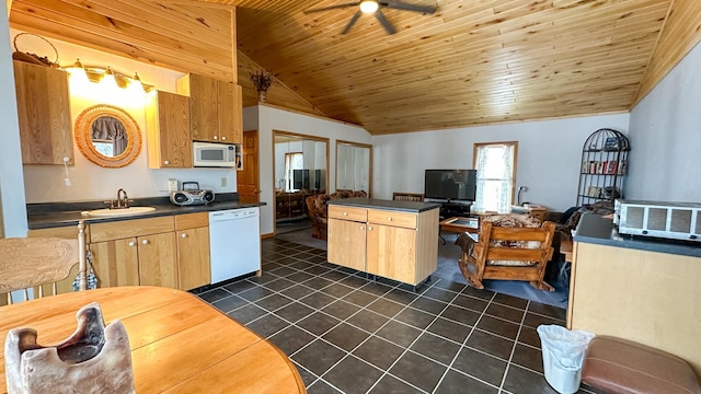 kitchen featuring white appliances, lofted ceiling, a sink, dark countertops, and dark tile patterned floors