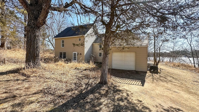 exterior space with a garage and dirt driveway