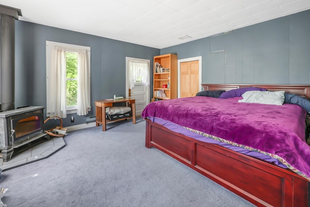28503 Ottawa Dr, Browerville, MN 56438 - bedroom with a wood stove, carpet floors, and a baseboard heating unit