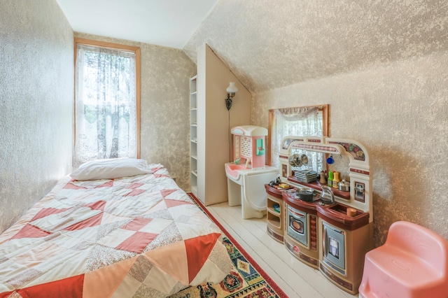 28503 Ottawa Dr, Browerville, MN 56438 - bedroom with lofted ceiling, a textured wall, and wood finished floors