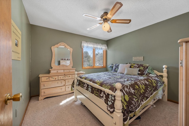 carpeted bedroom with ceiling fan, baseboards, and a textured ceiling