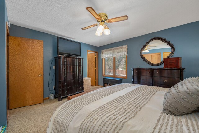 bedroom featuring baseboards, ceiling fan, a textured ceiling, and carpet