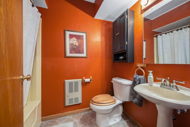 full bath with a shower with curtain, heating unit, toilet, and baseboards