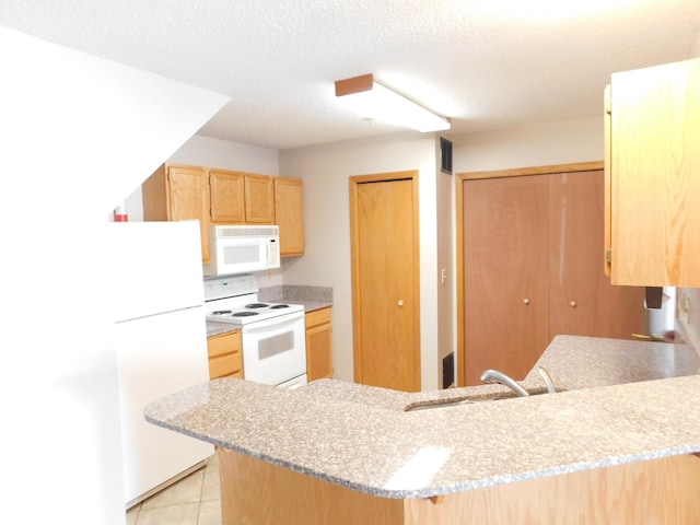 kitchen with white appliances, light tile patterned floors, a peninsula, light countertops, and light brown cabinetry