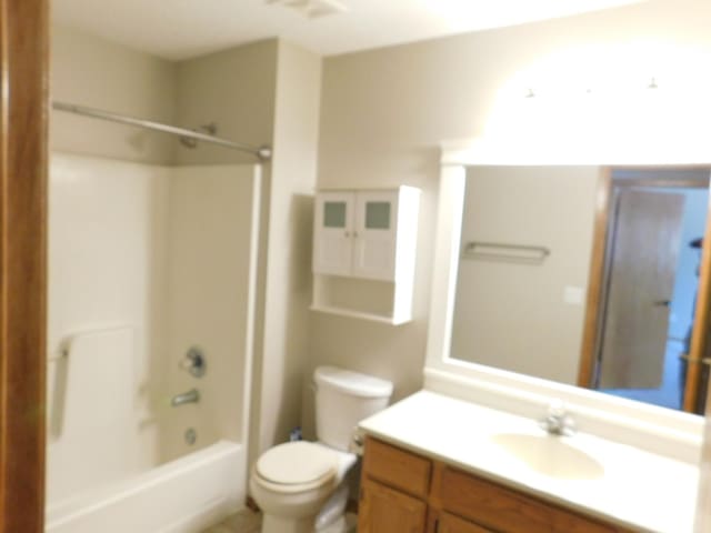 bathroom with toilet,  shower combination, and vanity