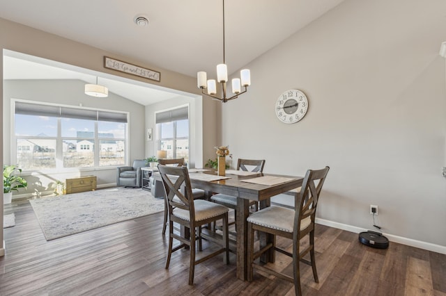 dining room featuring dark wood finished floors, lofted ceiling, baseboards, and an inviting chandelier