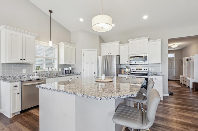 kitchen with stainless steel appliances, dark wood-type flooring, a kitchen island, and white cabinetry