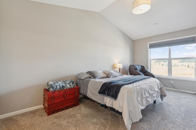 carpeted bedroom with baseboards and vaulted ceiling