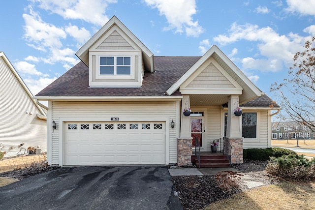 view of front of property featuring aphalt driveway, an attached garage, and roof with shingles