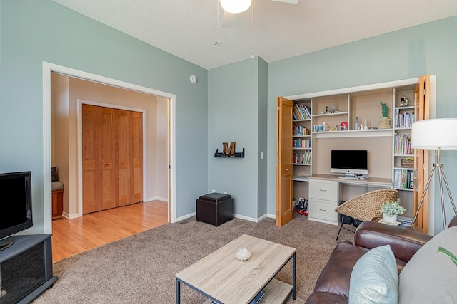 living area with baseboards, a ceiling fan, and carpet flooring