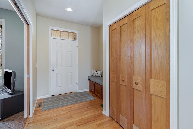 entrance foyer with visible vents, baseboards, and light wood-type flooring