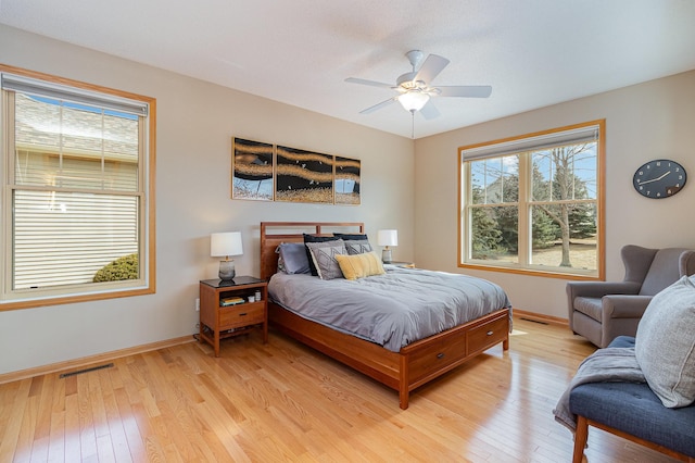 bedroom with visible vents, light wood-style flooring, baseboards, and ceiling fan