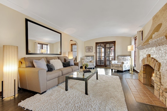 living area featuring a healthy amount of sunlight, dark wood finished floors, and a tile fireplace