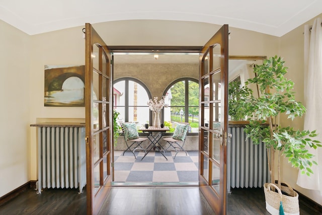 doorway featuring wood finished floors, radiator, french doors, and baseboards