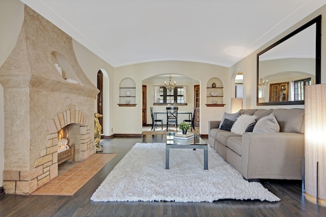 living area with wood finished floors, built in features, and a fireplace