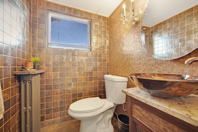 bathroom with vanity, tile walls, and toilet