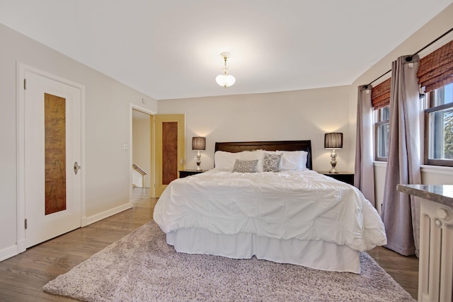 bedroom with baseboards and wood finished floors