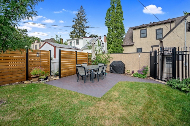 view of yard featuring a patio, a fenced backyard, and a gate