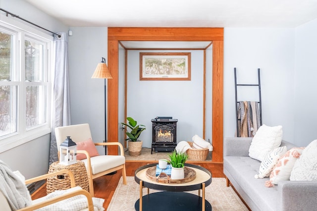 sitting room with a wood stove and wood finished floors