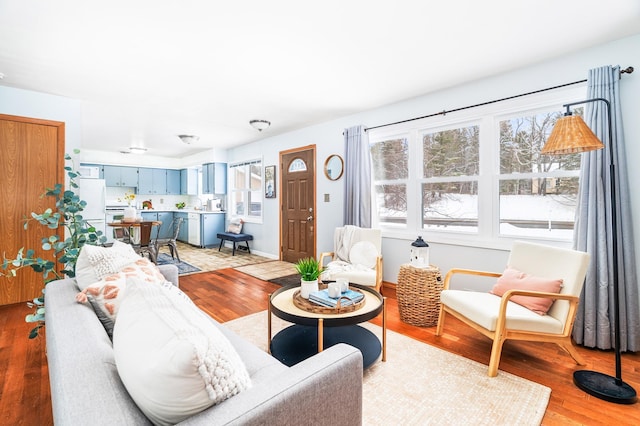 living area featuring baseboards and light wood finished floors