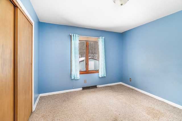 carpeted empty room with baseboards and visible vents