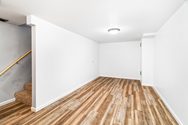 spare room with light wood-style flooring, visible vents, stairway, and baseboards