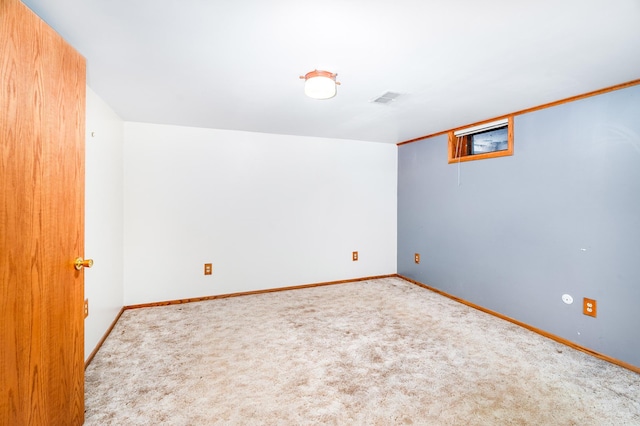 carpeted spare room featuring visible vents and baseboards