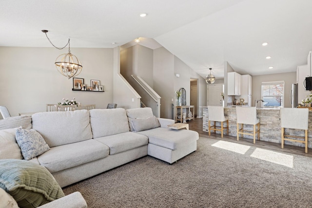 living area with stairs, wood finished floors, recessed lighting, and a chandelier