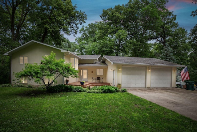 view of front of house with stucco siding, a front lawn, concrete driveway, and an attached garage