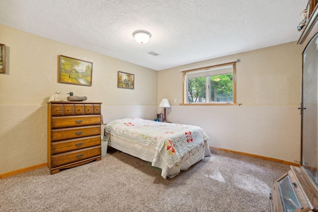 bedroom featuring visible vents, carpet, baseboards, a textured wall, and a textured ceiling