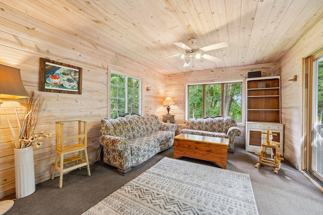 living room with a wealth of natural light, wooden walls, wood ceiling, and carpet floors