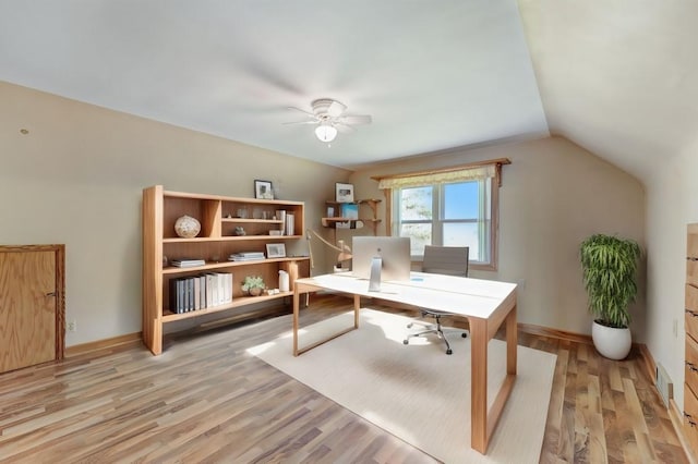 office featuring lofted ceiling, light wood-style floors, baseboards, and a ceiling fan