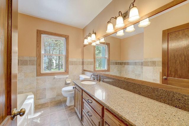 full bath with tile walls, toilet, a bathing tub, vanity, and tile patterned flooring