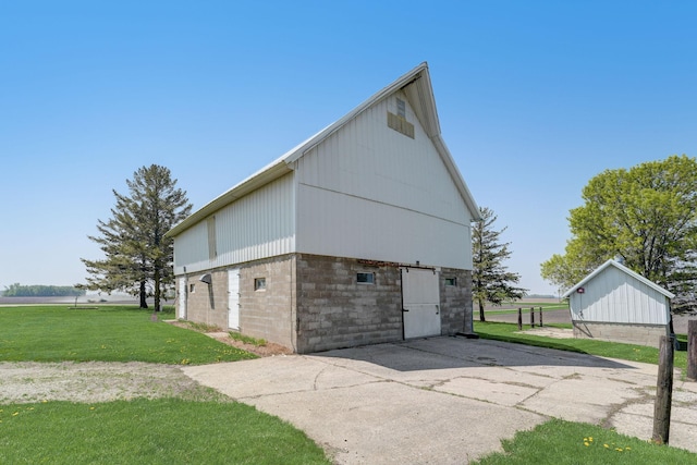 view of property exterior with an outbuilding, a yard, and a barn