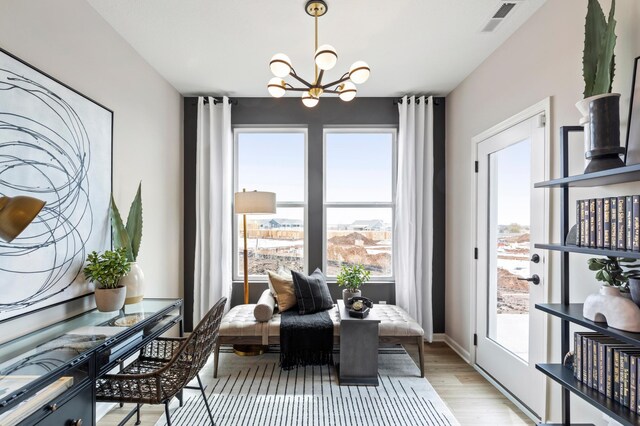 dining room featuring a chandelier, baseboards, visible vents, and light wood-style floors